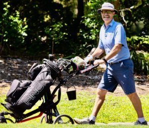 7. Smiling man pushing golf buggy